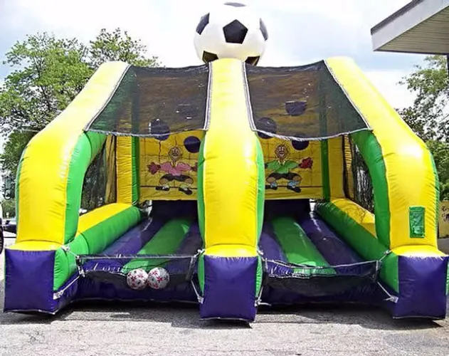 Colorful inflatable soccer-themed game with two lanes and large soccer ball on top outdoors