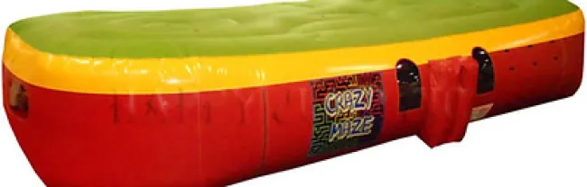Large inflatable obstacle course with green and yellow top and red sides, labeled Crazy Maze.
