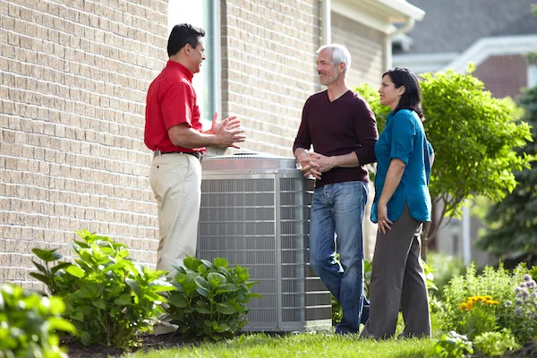 HVAC Technician talking with Client over AC unit