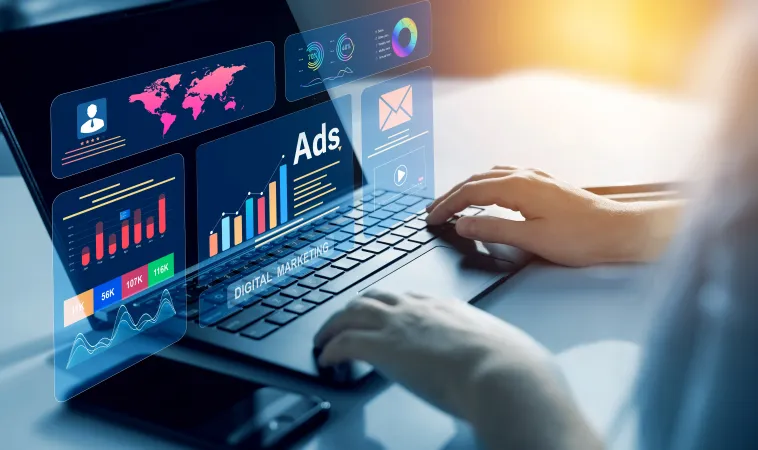 Person working on laptop with digital marketing ads and analytics charts floating above keyboard