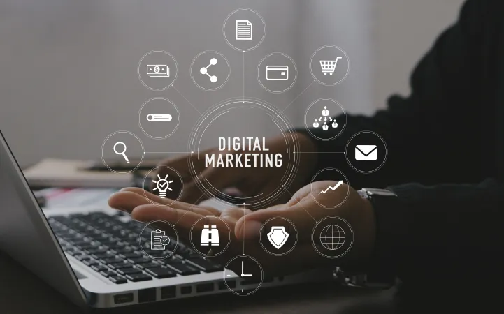 Person using laptop with digital marketing icons floating above hand illustrating online business concepts.