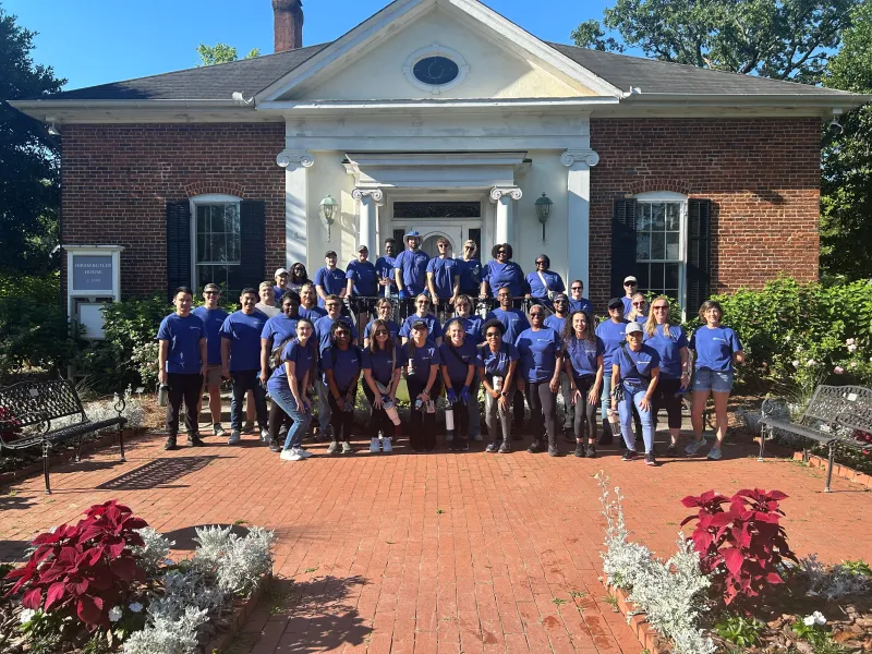 a group of people posing for a photo in front of a house