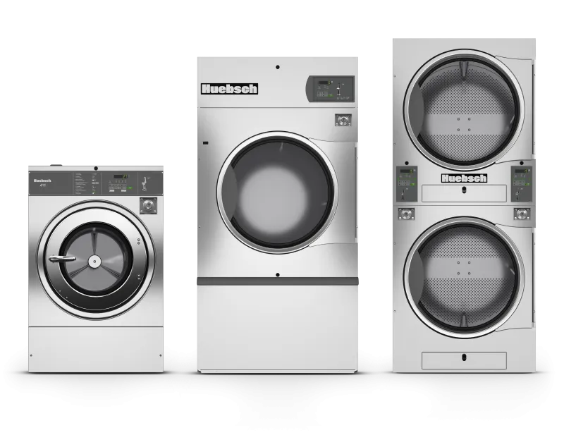 Three silver Huebsch commercial laundry machines including a front-load washer, dryer, and stacked dryer units.