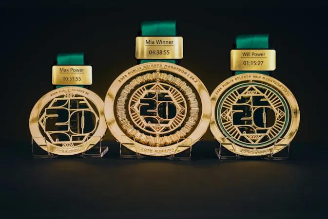 Three gold marathon medals with green ribbons and engraved winner names and times against a dark background.