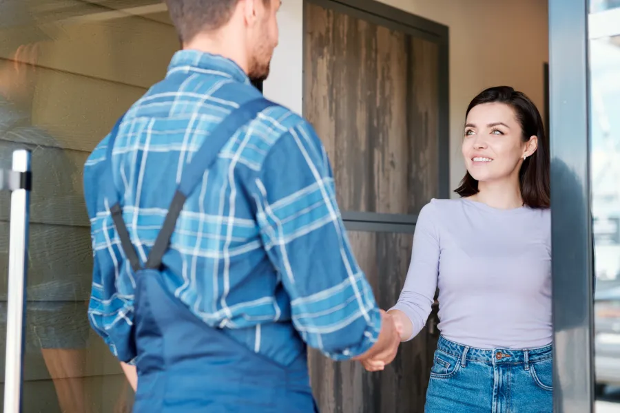a man and a woman shaking hands at the door