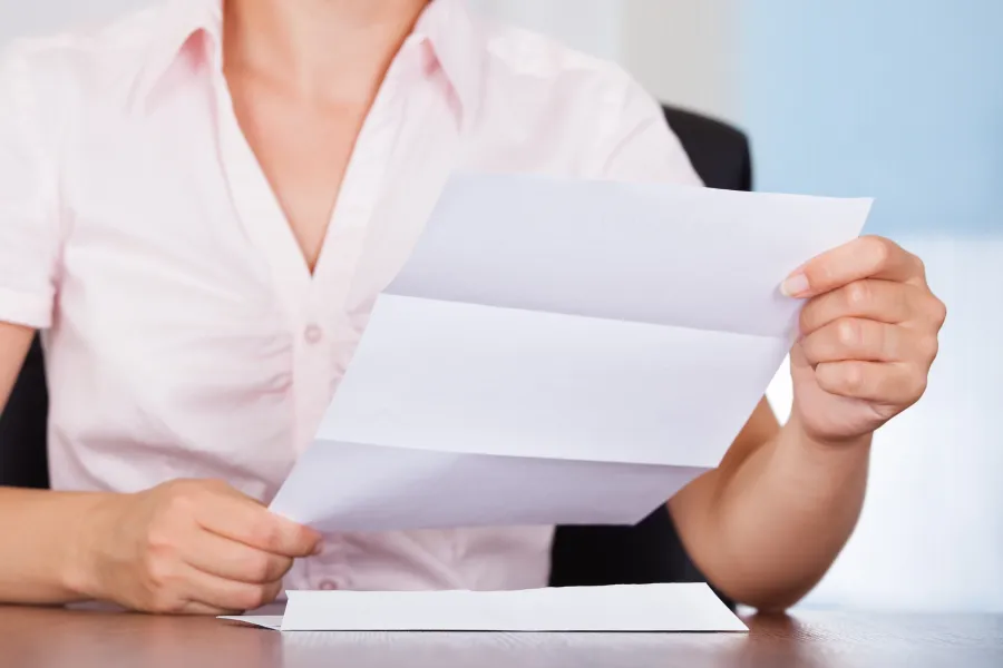A woman reading a Business Letter she just took from an Envelope