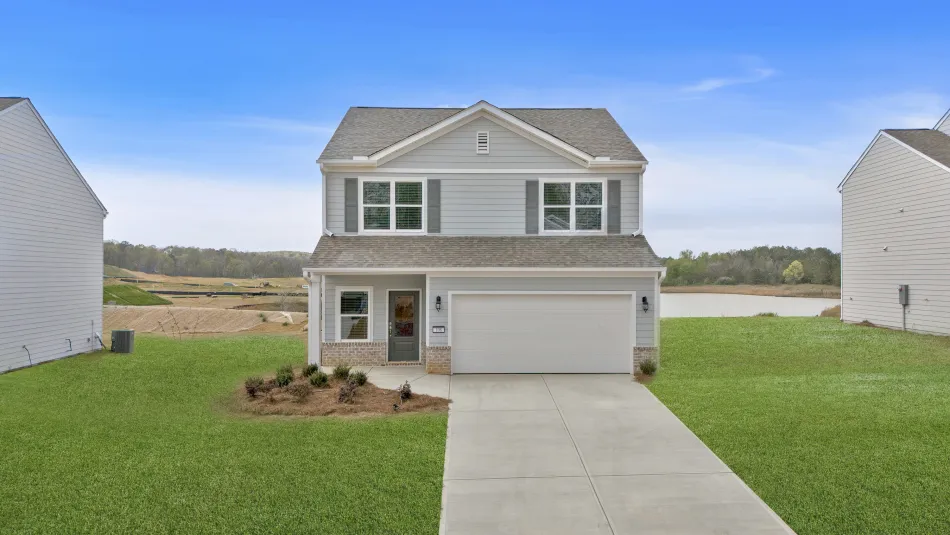 Two-story gray house with white trim and a two-car garage in a suburban neighborhood under blue sky