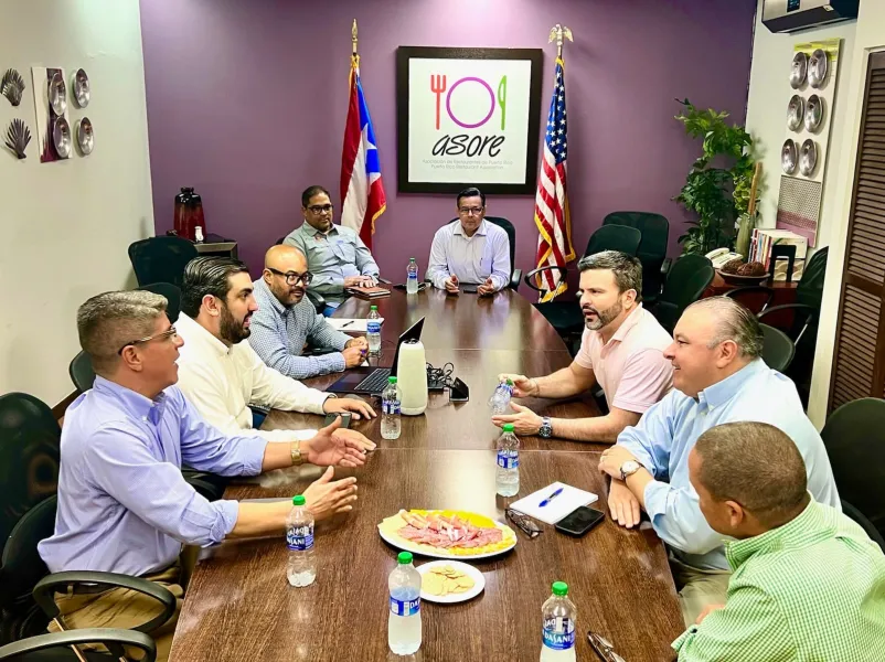 a group of men sitting around a table having a meeting