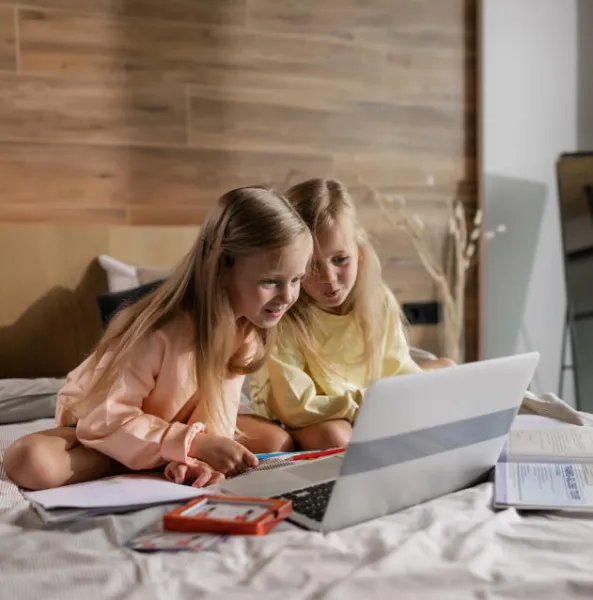 a couple of girls looking at a laptop