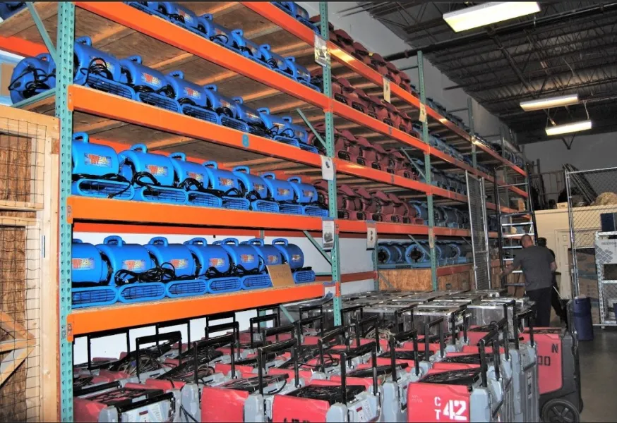 a large warehouse with a large stack of blue and red containers