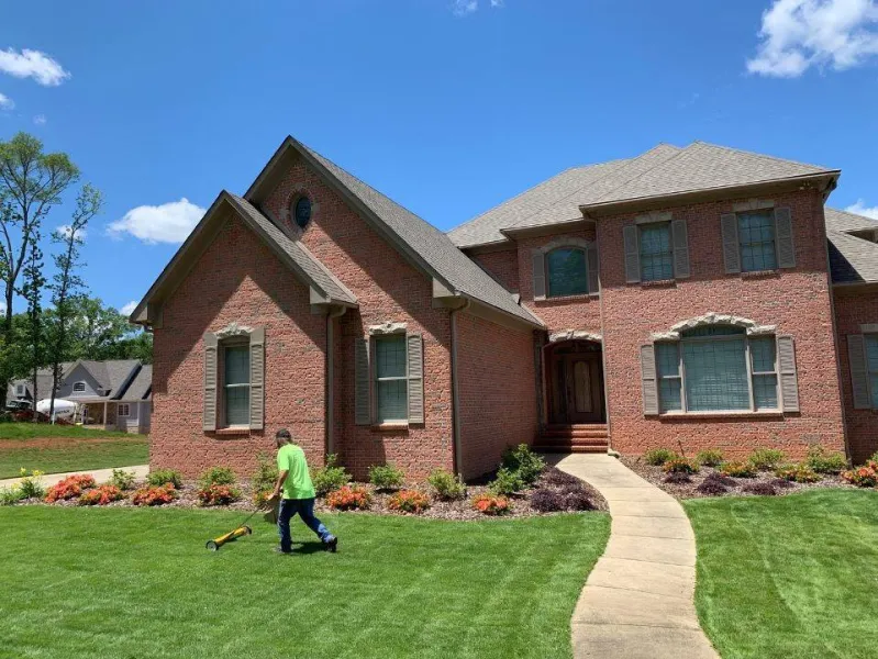 a person walking in front of a brick house