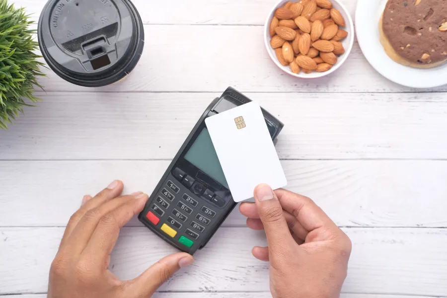 a person holding a phone and credit card