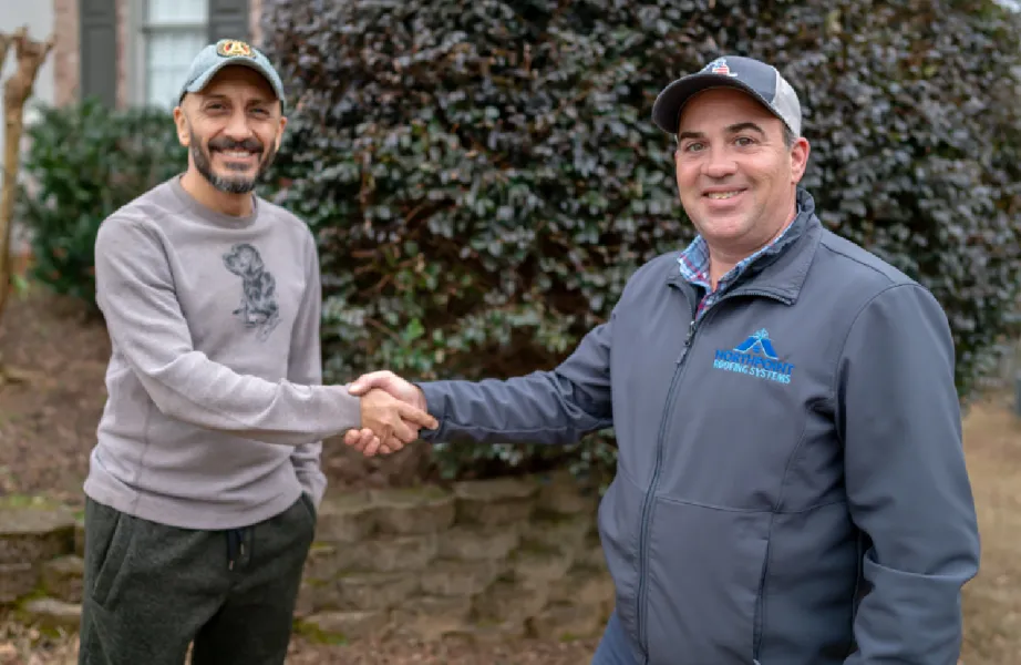 a Northpoint employee helping with roof insurance claim and shaking hands with a happy client