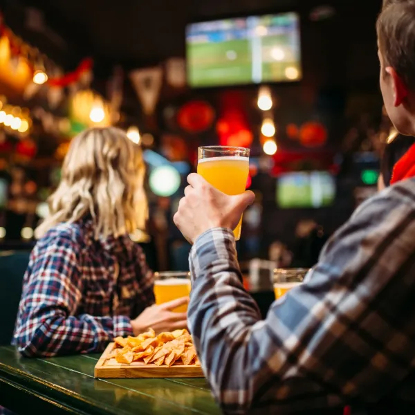 a man and a woman sitting at a table with food and drinks