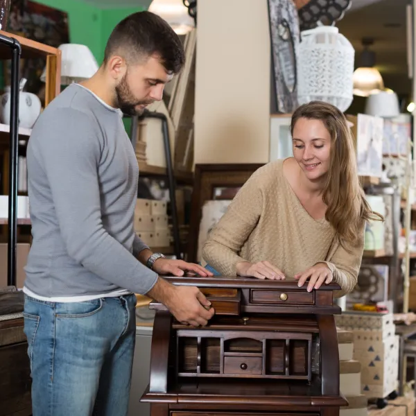 a man and a woman looking at an antique