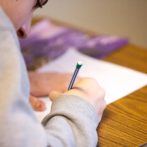 a person writing on a piece of paper