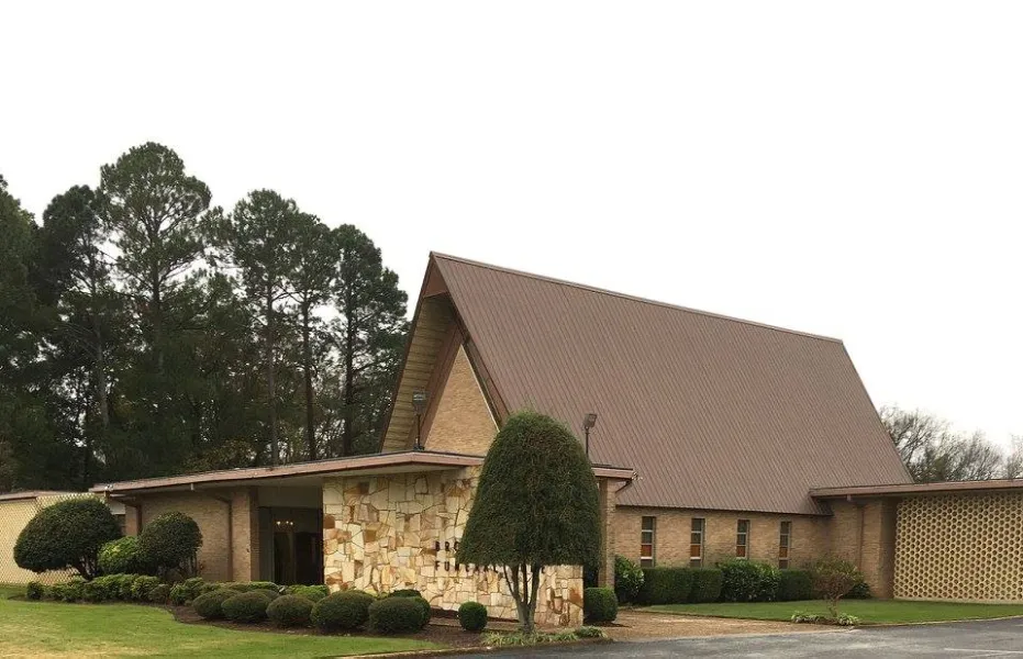 a large brick building with grass in front of a house