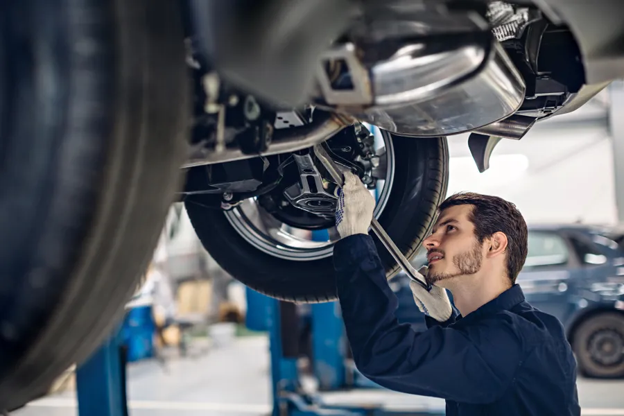 a car mechanic working underneath a car