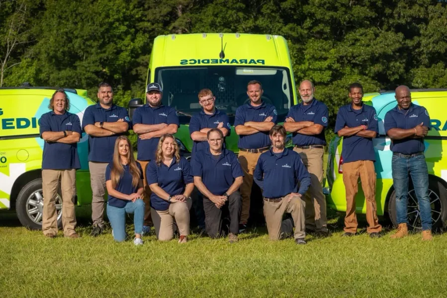 a group of people posing for a photo in front of a yellow truck
