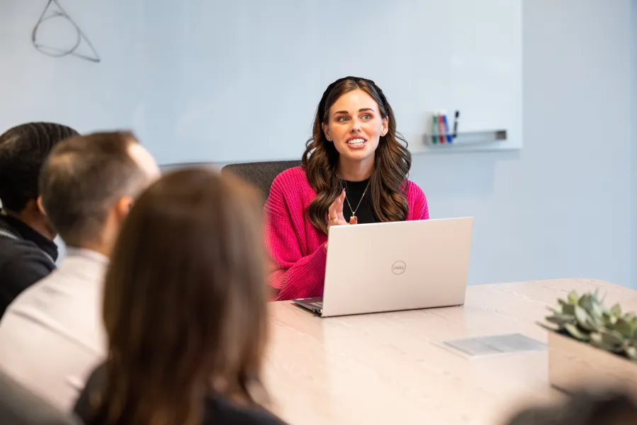 a woman sitting at a desk smiling