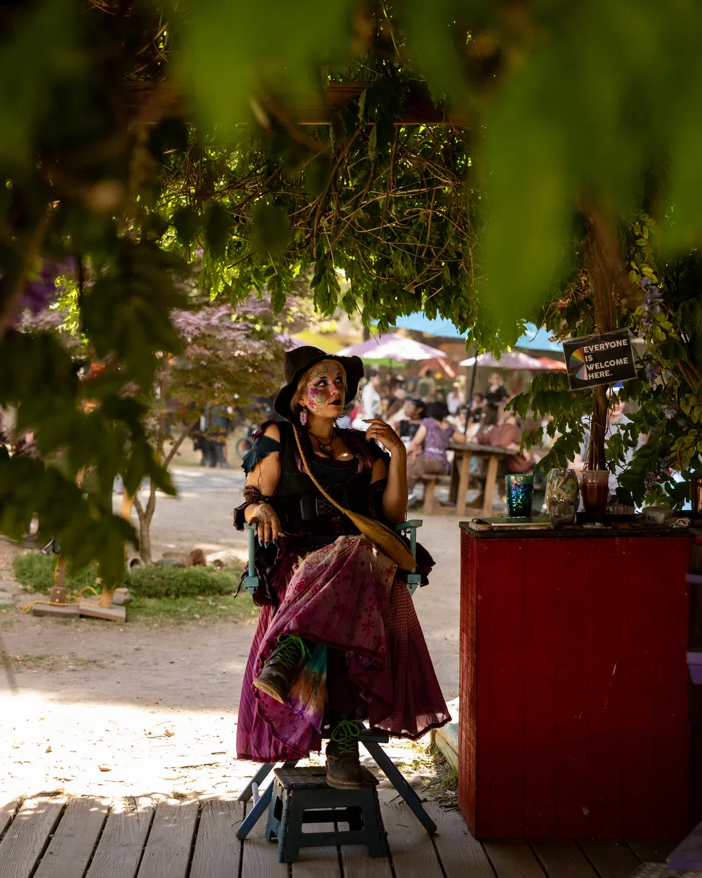 A smiling costumed performer sharing a candid moment with another performer at the Festival.