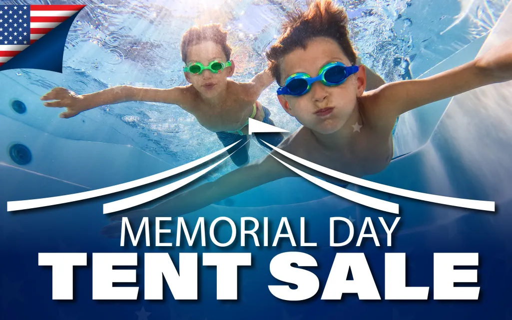 Two boys wearing goggles swimming underwater in a pool with Memorial Day Tent Sale text overlay.