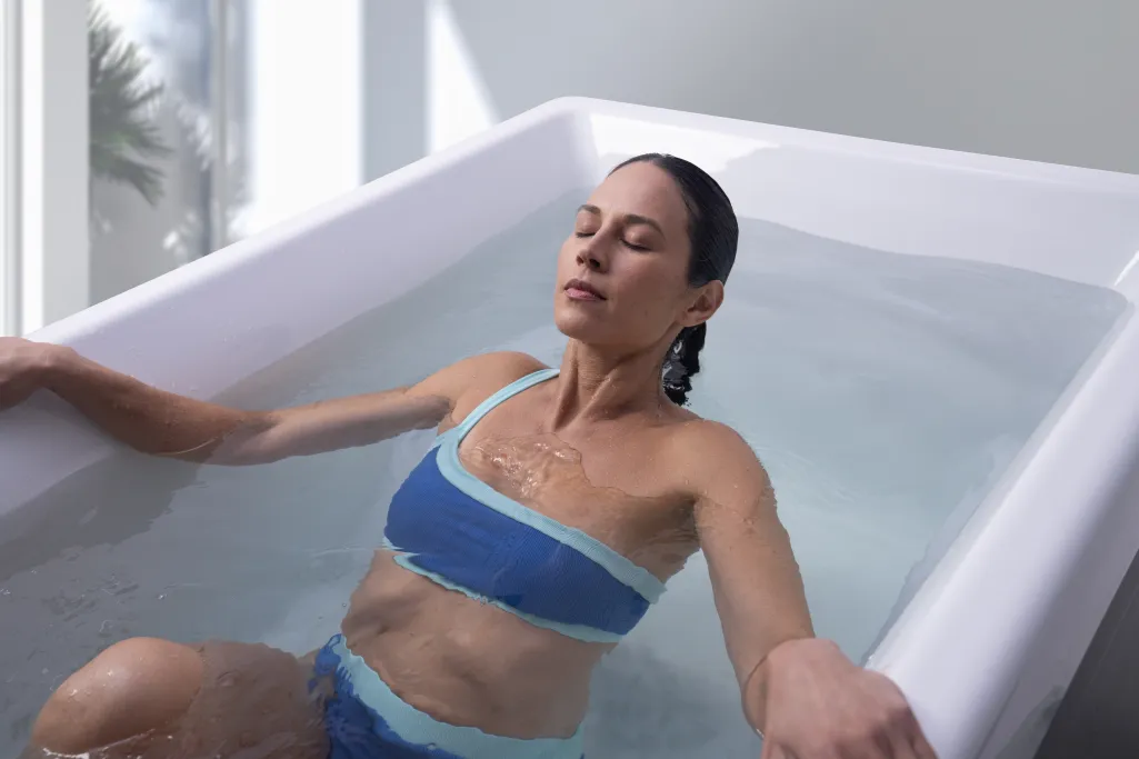 Woman relaxing in a spa tub during Georgia Spa Co. mid-year summer clearance sale promotion.