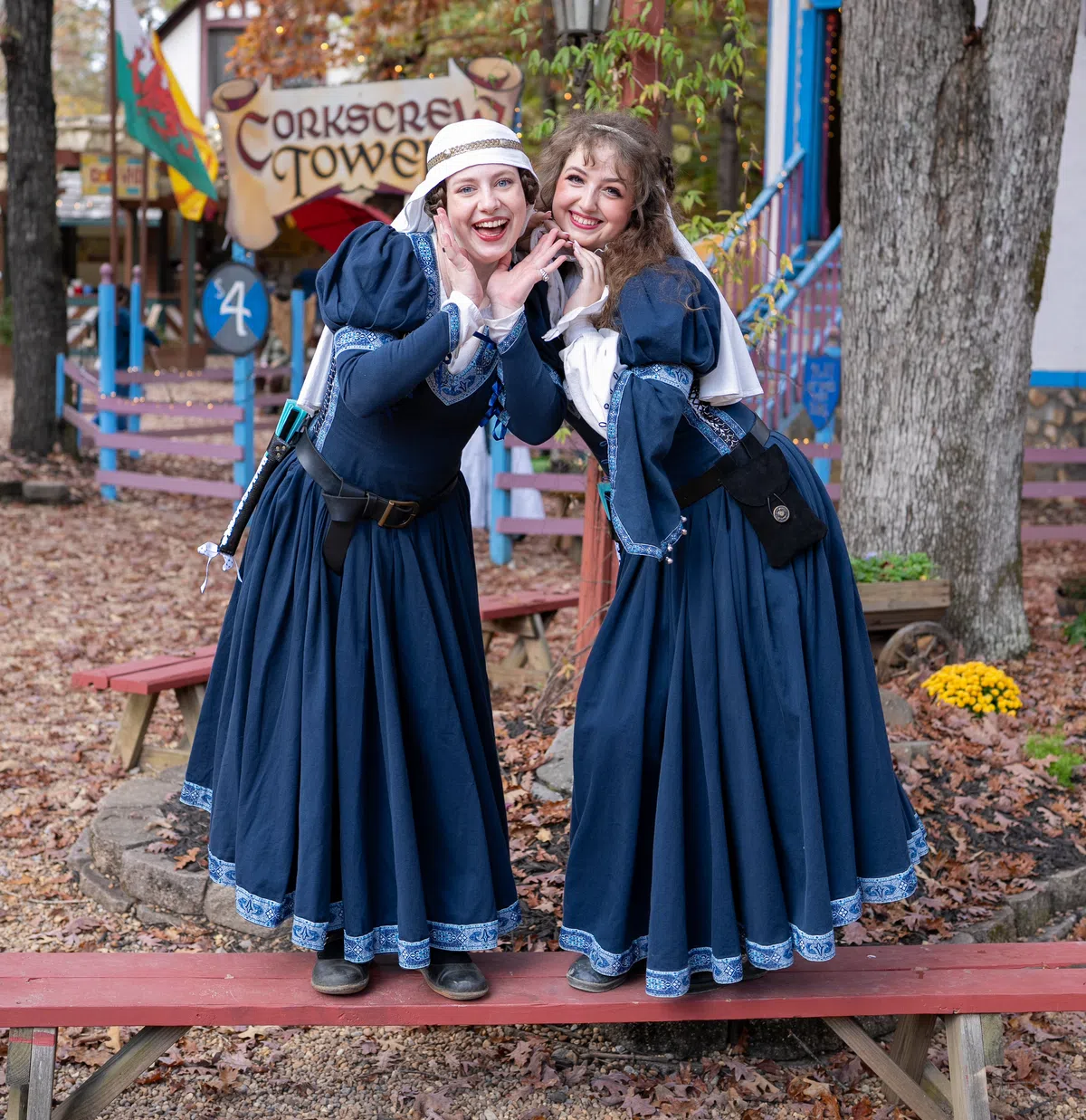 Costumed Festival characters sharing a laugh in the village.
