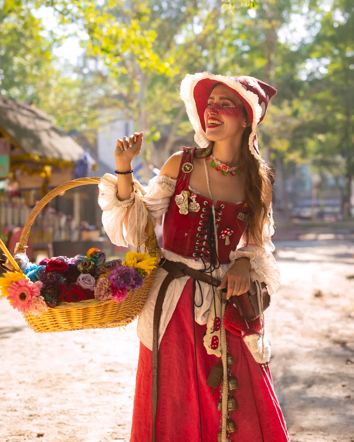 A costumed artisan offering roses in the Festival village.