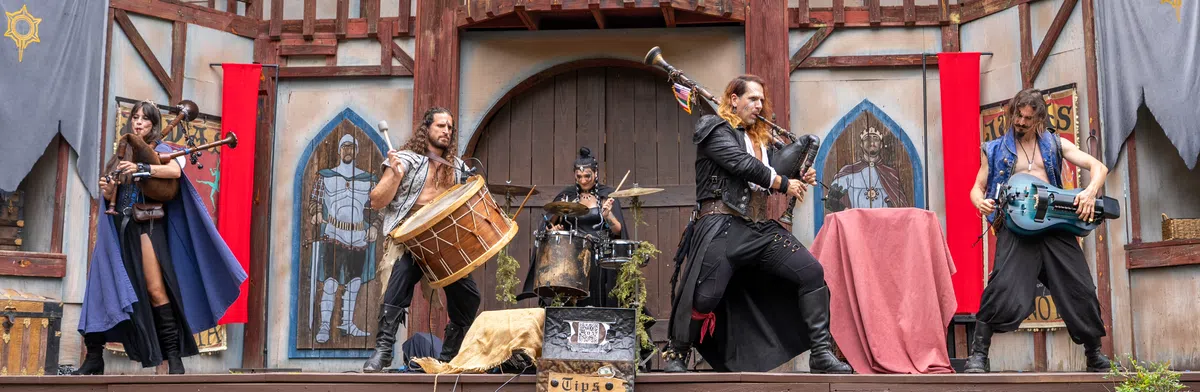 A wide shot of a bagpipe band performing on a Festival stage.