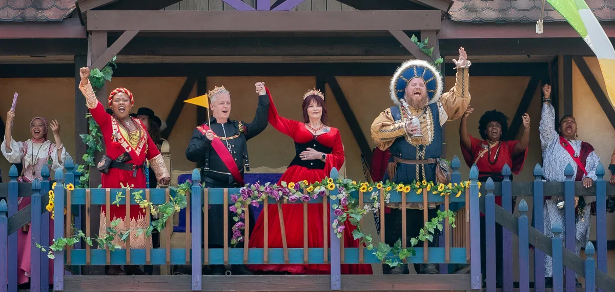 A bride and groom with the King and Queen on the jousting arena dais