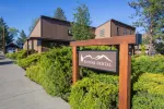 Sisters Dental sign with mountain logo outside brown building surrounded by green bushes and trees on sunny day