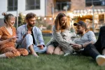 a group of people sitting on the grass