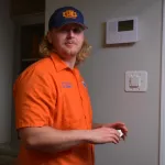 Estes HVAC Professional installing a Thermostat