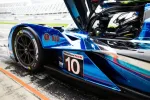 Close-up of blue race car number 10 with WeatherTech sponsorship and Michelin tires in a pit lane.