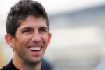 Close-up of a cheerful young man smiling with short dark hair and casual black shirt