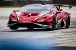 Red Lamborghini race car speeding on track during motorsport event with sponsor logos and aerodynamic features