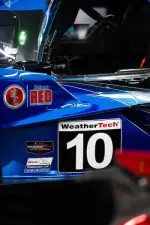 Close-up of blue race car with WeatherTech number 10 and racing decals at endurance event.