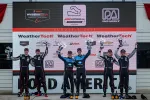 IMSA WeatherTech race winners on podium holding trophies at Road America event on August 7, 2022.