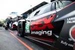 Close-up of black race car with DEX Imaging logo and number 45 at a pit stop during a race event.