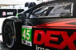 Close-up of black race car number 45 with red DEX logo and WeatherTech sponsorship in a garage setting.