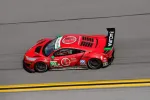 Red Acura NSX GT3 racing car with number 93 speeding on a racetrack with yellow lines.