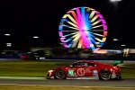 Red No. 93 race car speeding on track at night with colorful Ferris wheel lights in background