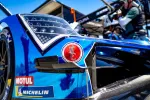 Close-up of blue race car front with headlights, sponsor logos MOTUL and Michelin, and racing decals.