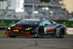 Black and green Lamborghini race car with DEX Imaging branding speeding on race track during event.