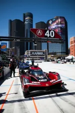Red Acura race car number 40 in pit lane with city skyscrapers and Chevrolet logo in background on sunny day