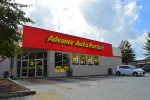 Advance Auto Parts store exterior with red signage and parking lot on a partly cloudy day
