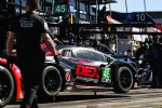 Black race car number 45 with DEX imaging logo in the pit lane surrounded by crew members.