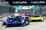 Blue Acura race car leads a group of colorful race cars on a city street circuit under Acura banners.
