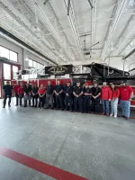 Carroll County Fire Rescue team standing in front of a red fire truck inside the fire station garage.